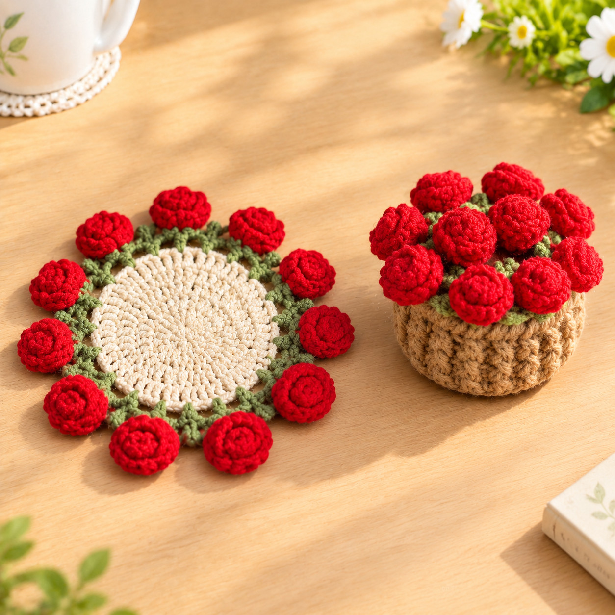 A crocheted rose coaster lying flat on a wooden table in sunlight: a cream centre, a green edging of little pointed leaves and red rolled roses all round the rim, beside a small tan crocheted flower pot filled with red roses